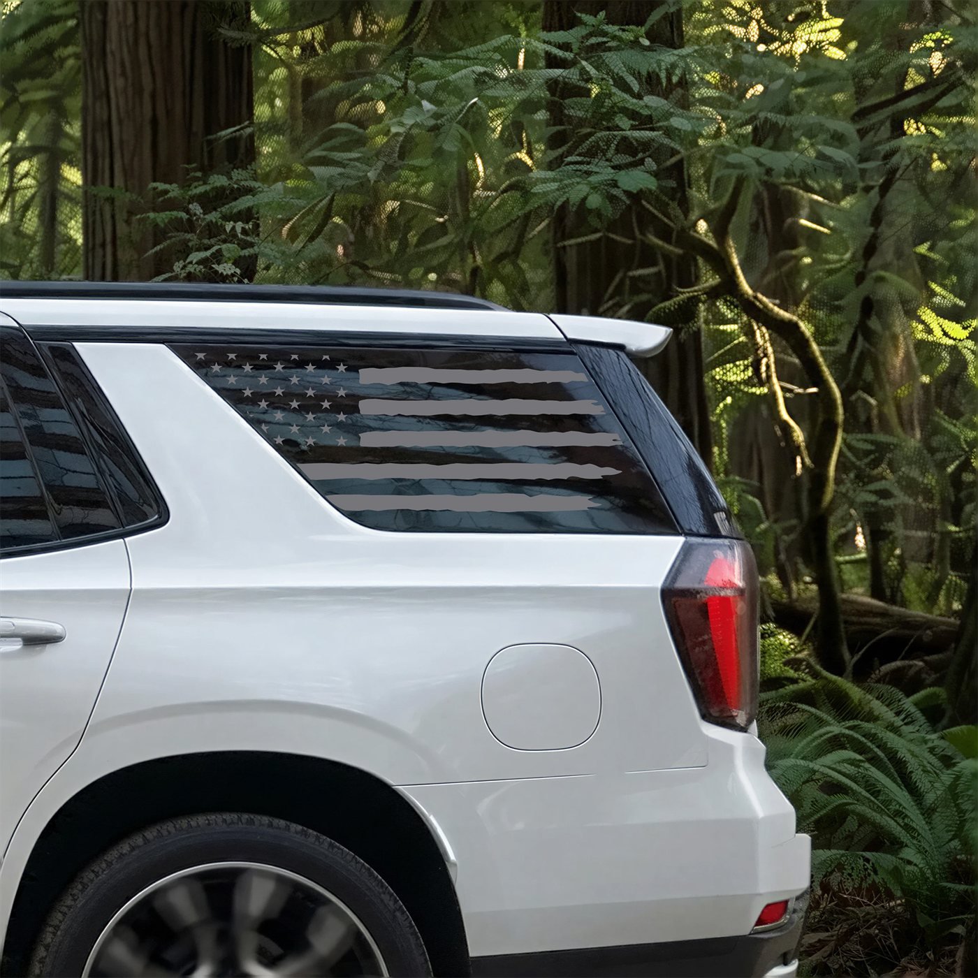Distressed American flag decal on the rear quarter window of a white Chevrolet Tahoe